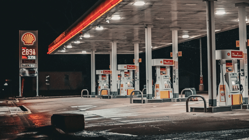 Illuminated fuel station at night along the highway.