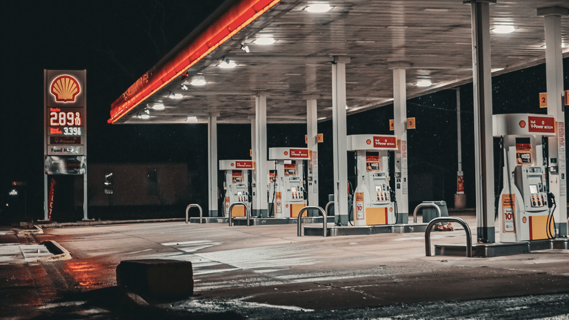 Illuminated fuel station at night along the highway.