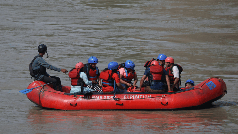 People on a boat rafting on a river.