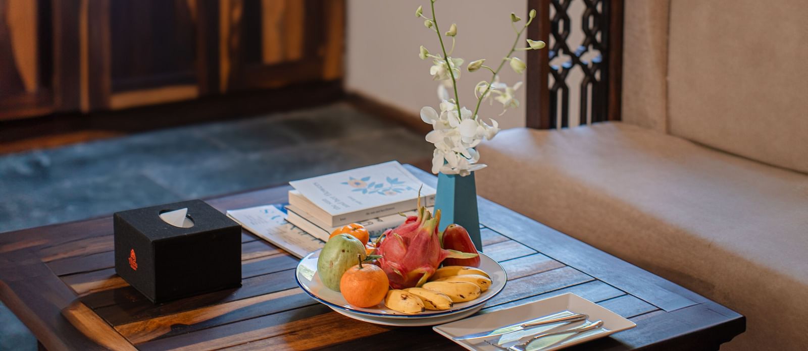 A close up shot of a coffee table in front of a cream-colored sofa - Alibu Resort Nha Trang