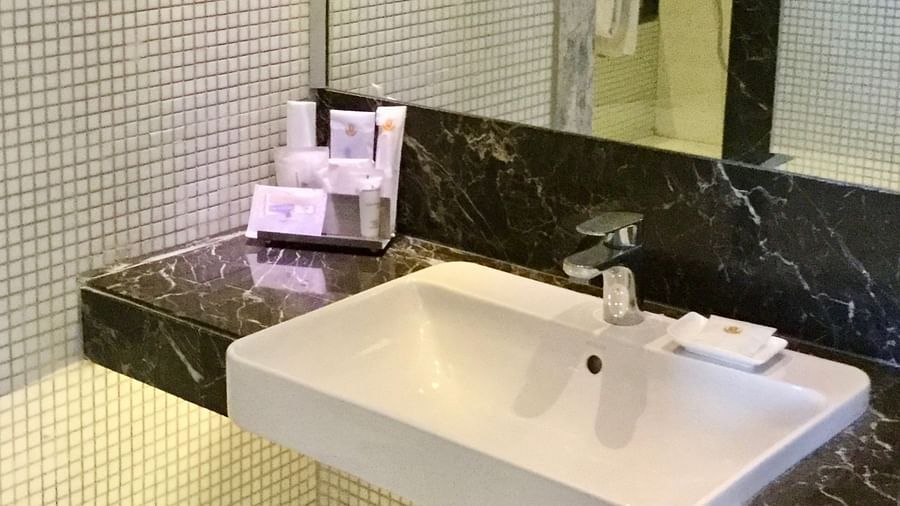 A wash basin with bathroom essentials kept besides it along with a huge mirror above the basin - Ramada by Wyndham, Ghaziabad, Vasundhara