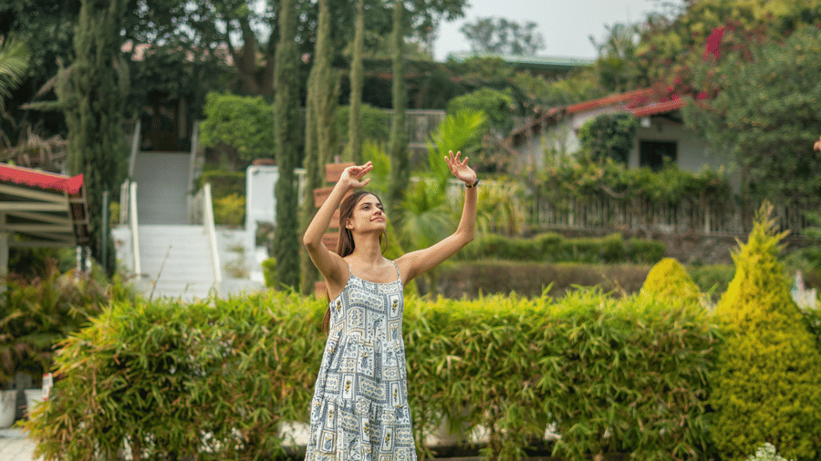  A girl playing in a lawn with a ball featuring plants and trees in the backdrop at Neer Ganga. 