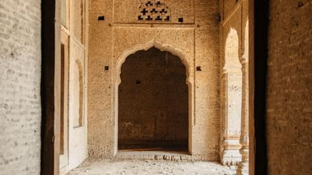 Interior view of a fort showcasing arched doorways and rustic heritage architecture.