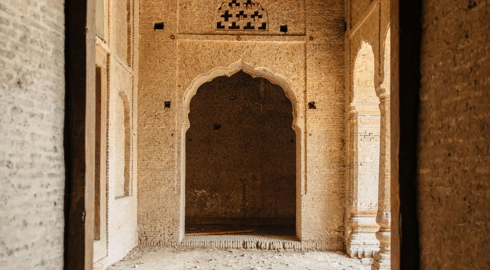 Interior view of a fort showcasing arched doorways and rustic heritage architecture.