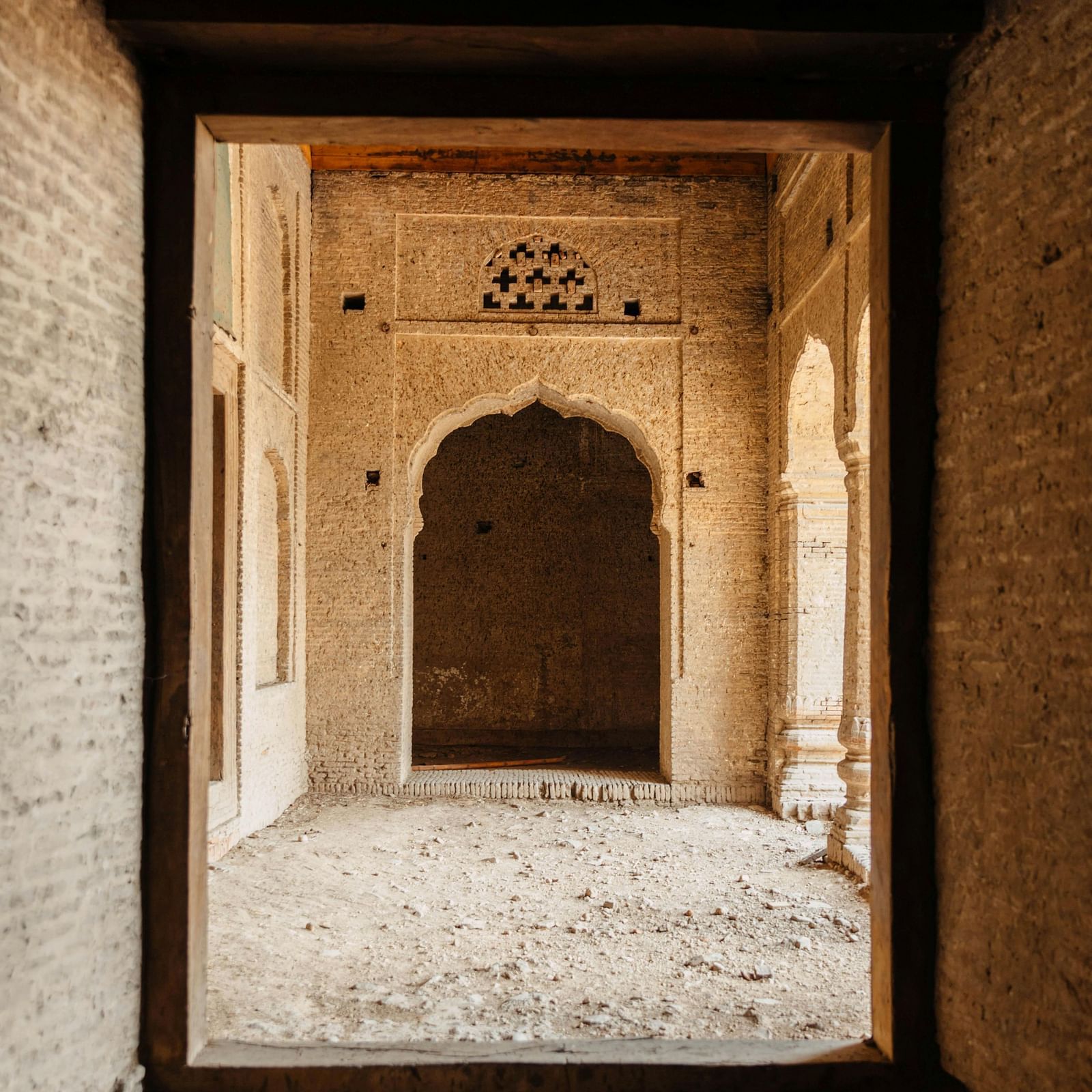 A stone archway leading to a series of ancient doors