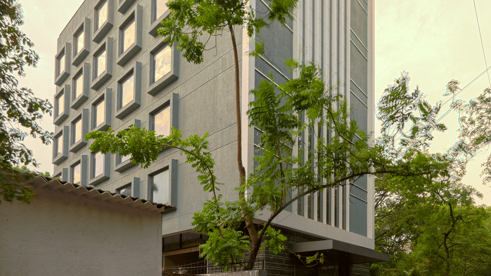 Facade image of Nexstar Suites in pune with trees next to it