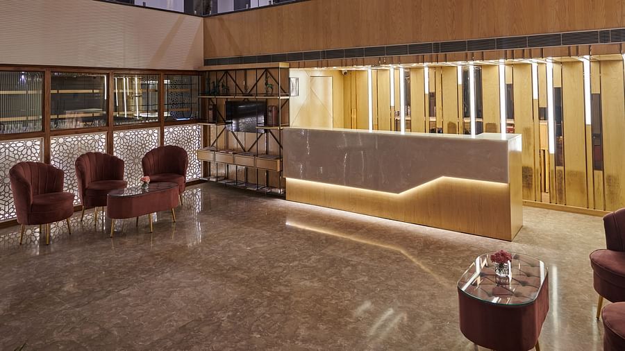 An image of the hotel lobby with a desk illuminated by bright light - Deventure Sarovar Portico, Patel Nagar