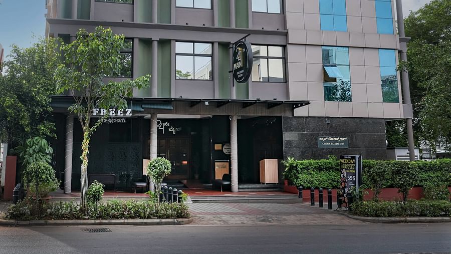 A daytime view of our hotel facade surrounded by greenery - Cross Roads Inn, Bengaluru