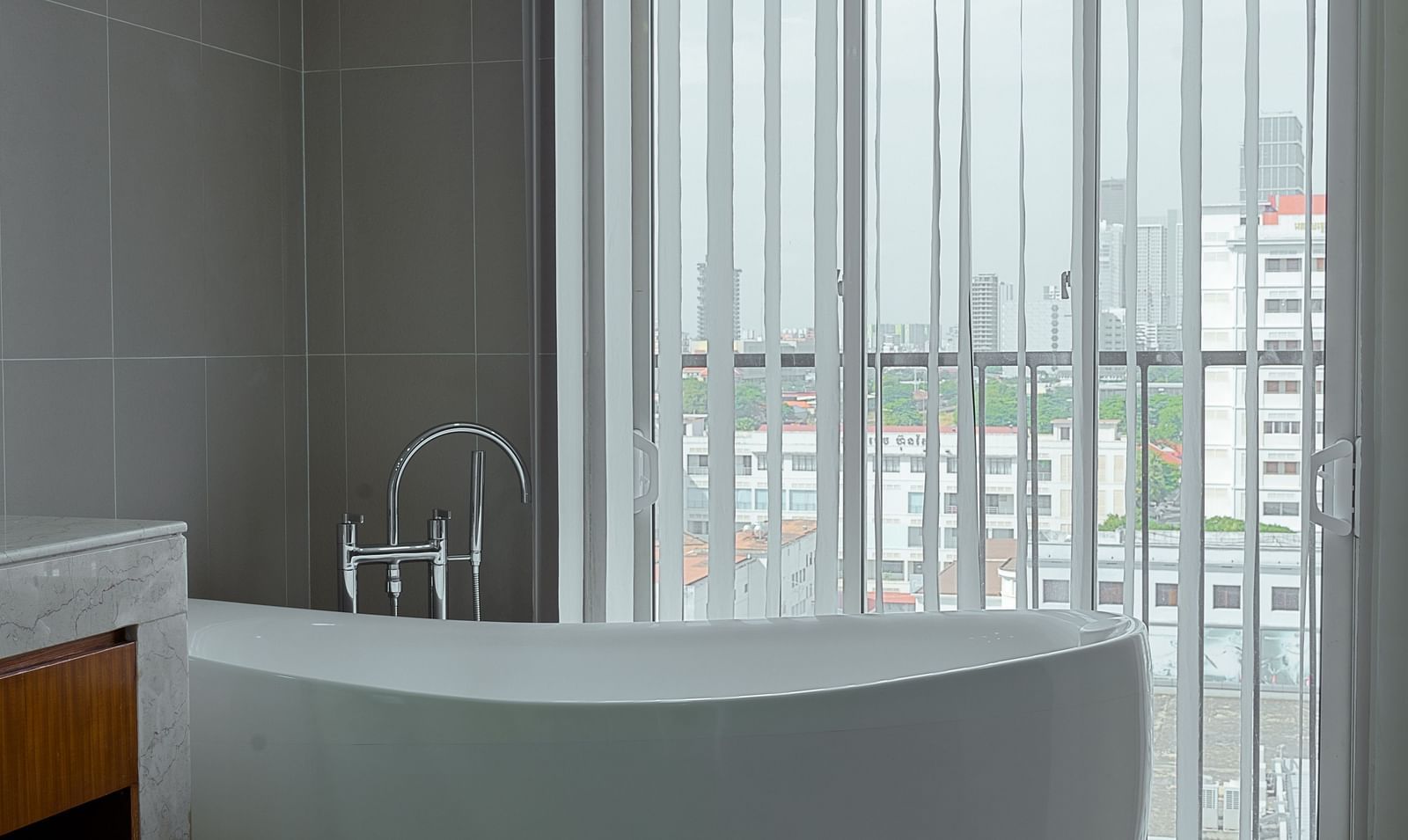 A bathroom with a standalone bathtub and floor-to-ceiling windows | Penthouse | Central Mansions, Phnom Penh
