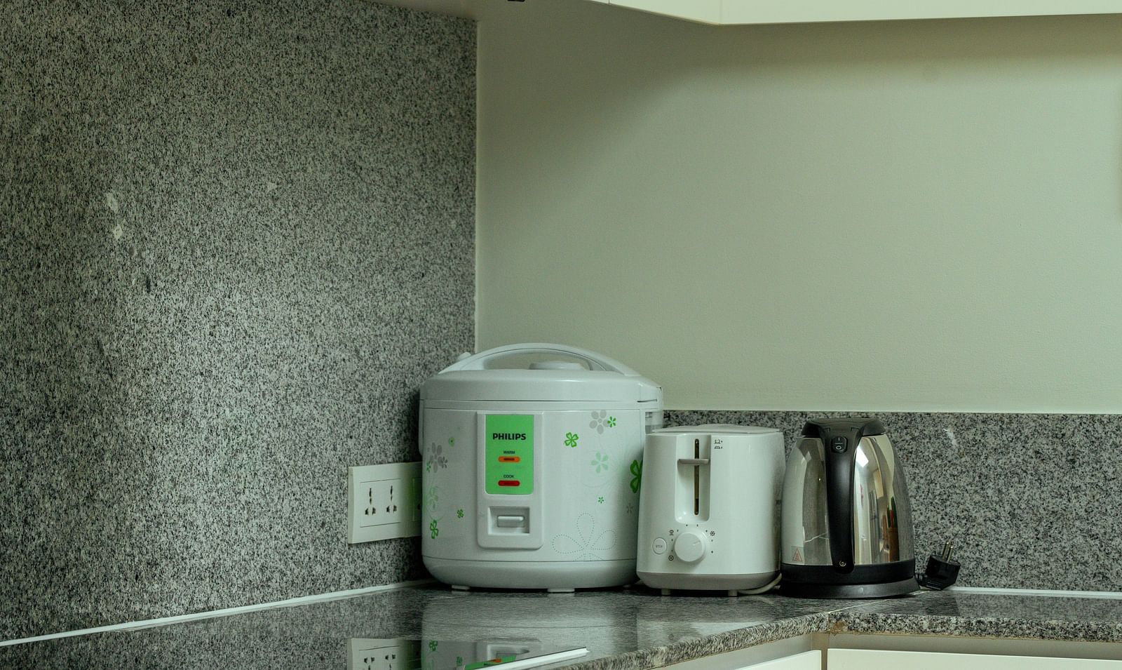 A modern kitchen with white cabinets, a stainless steel stove, and a rice cooker on the counter | Penthouse | Central Mansions, Phnom Penh