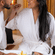 Couple enjoying breakfast in bathrobes at Featherlite Evoma Hotel, seated together with a tray of food and beverages placed between them.