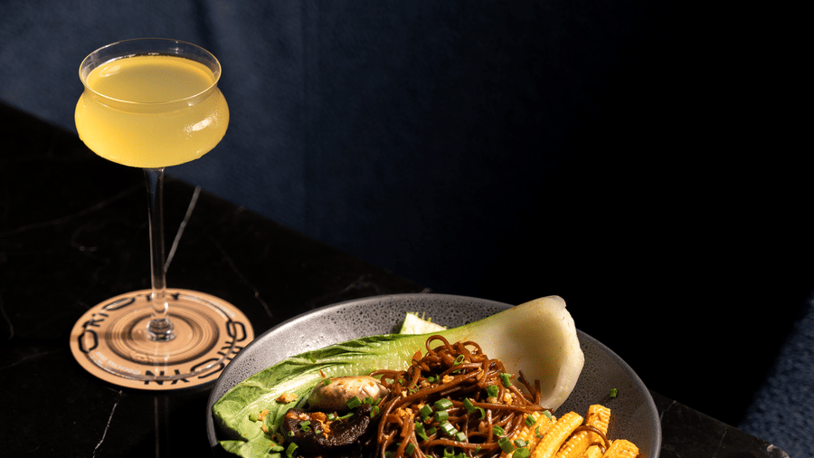 Plate of food and a drink placed on a table at Origyn, Merlis Hotel, Coimbatore.