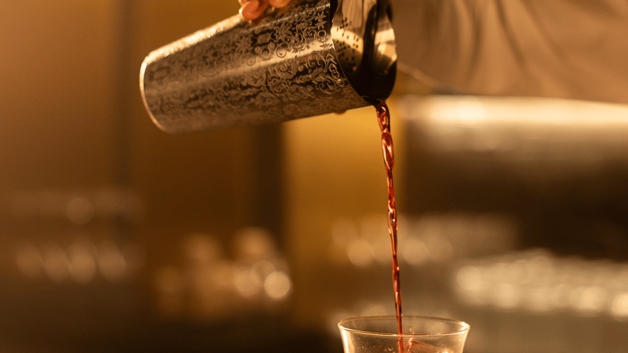 Liquid being poured into a glass from a bottle at Origyn bar, Merlis Hotel, Coimbatore.
