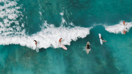 Aerial view of people surfing over the waves 