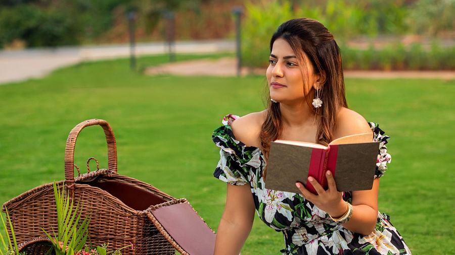 Woman reading a book during a garden picnic at The Dukes Retreat’s lush lawn area