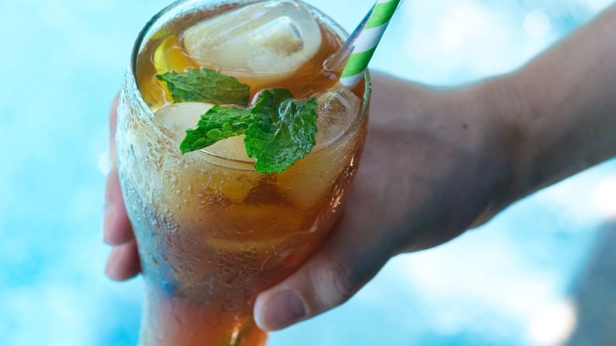 A person holding a glass of Lemon Iced Tea | Mango Hill, Pondicherry