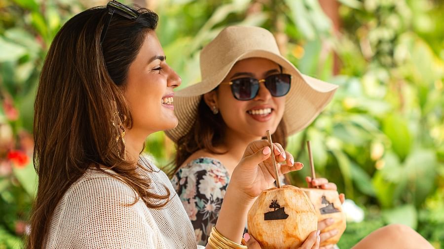 Friends enjoying coconut drinks at the garden café of The Dukes Retreat, surrounded by greenery