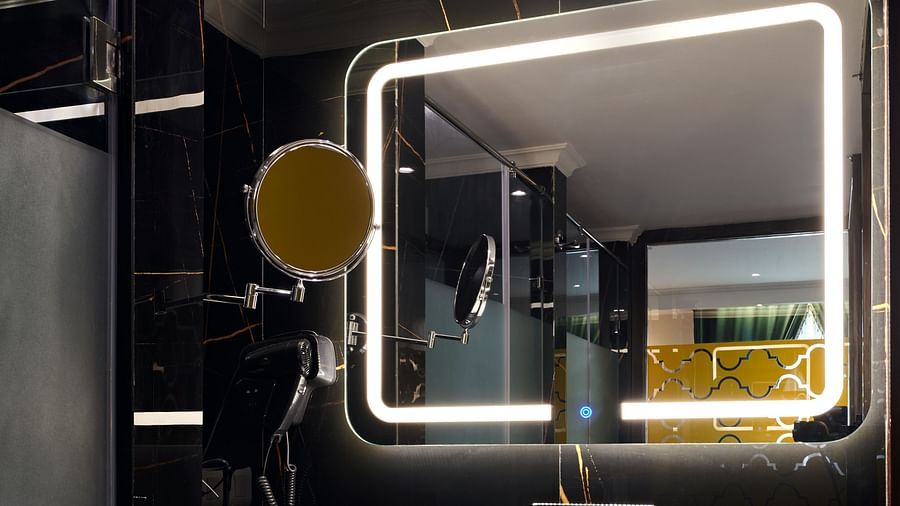 An image of the vanity counter with a wall mounted mirror and a sink below it - Deventure Sarovar Portico, Patel Nagar