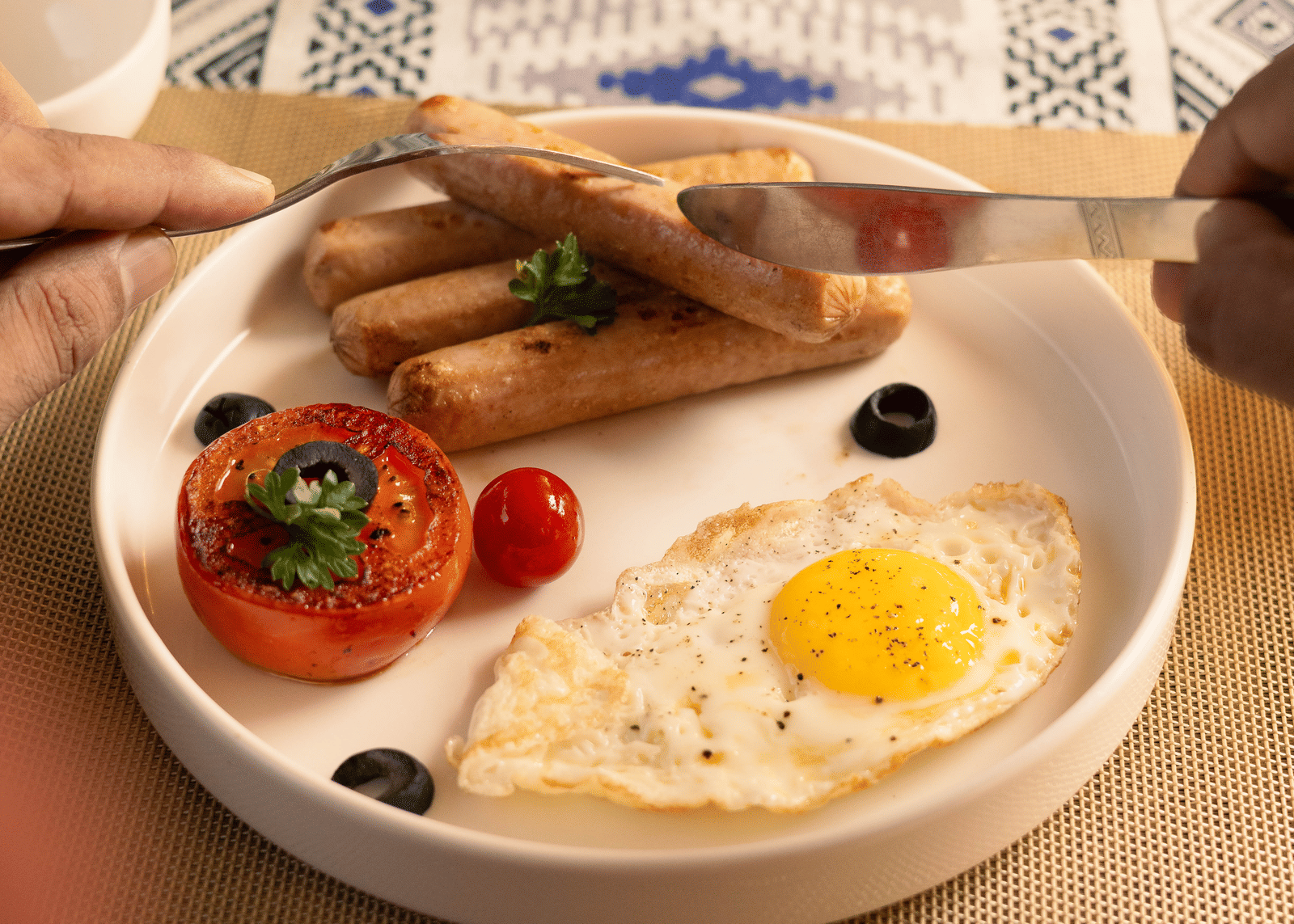 A simple breakfast of fried eggs, grilled sausages, and a slice of tomato on a small white plate - Megha Resort & Villas, Dehradun