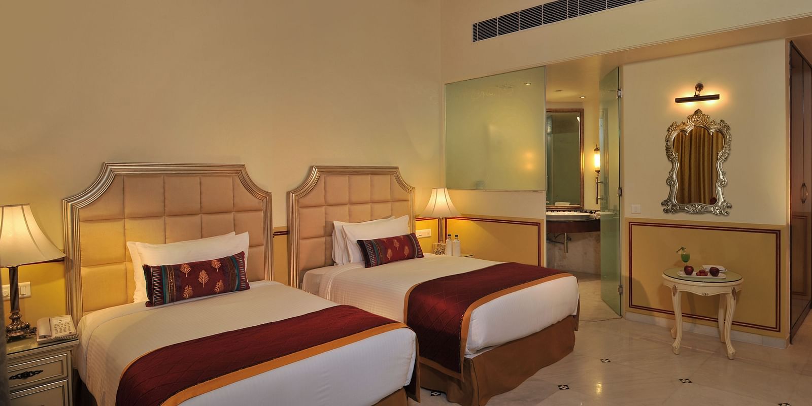 Image of a room with two beds and lamps on the sides of the bed at Rajasthali Resort & Spa Jaipur.