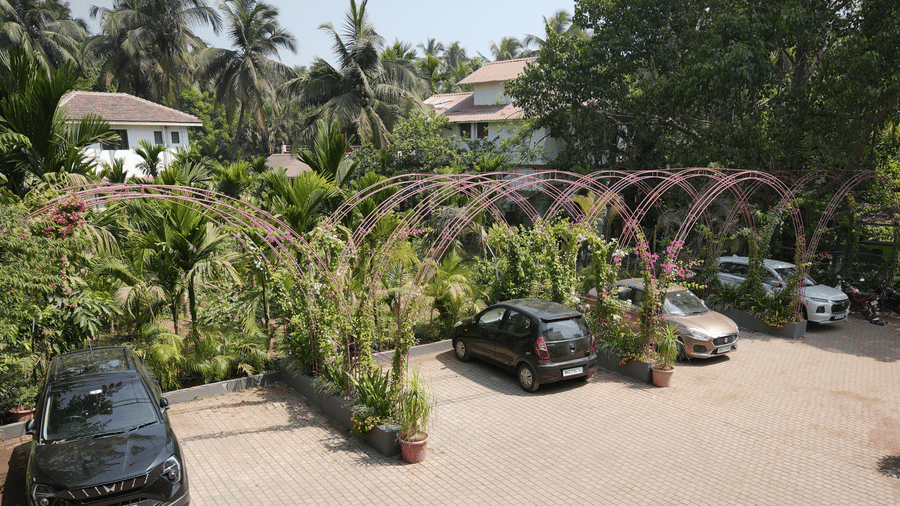 A top view of vehicles parked in a brick courtyard amongst lush green trees at Bougainvillea, Alibaug.