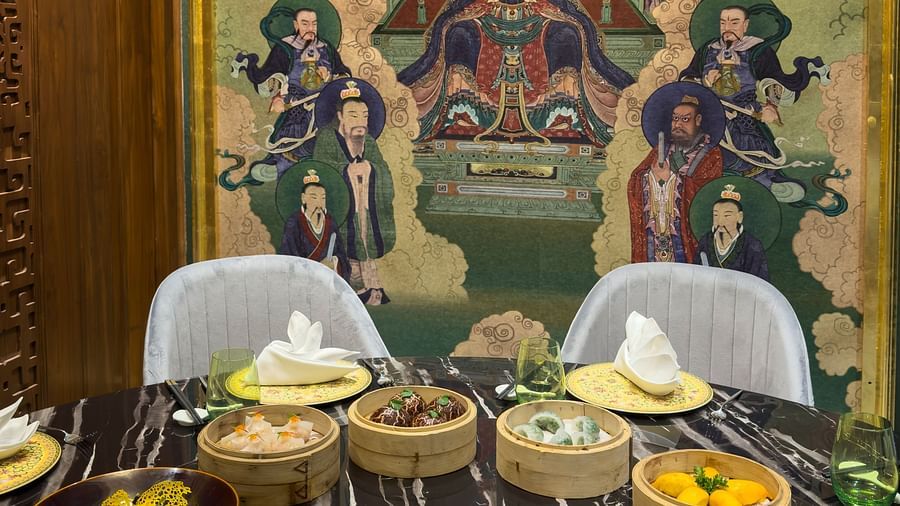 an image over the dining table with two chairs at the end with a delicious spread of dishes served at the jade - The Claridges New Delhi