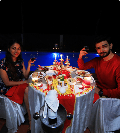 Image of two people holding up a glass of drink and posing for the lens.