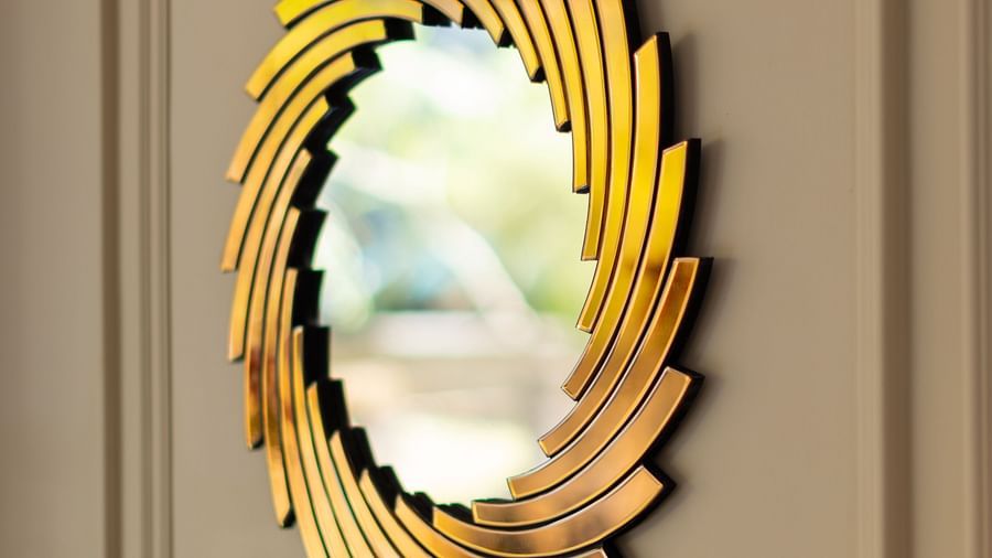 An oval mirror hung on a wall in the Lobby | Renest Calangute, Goa