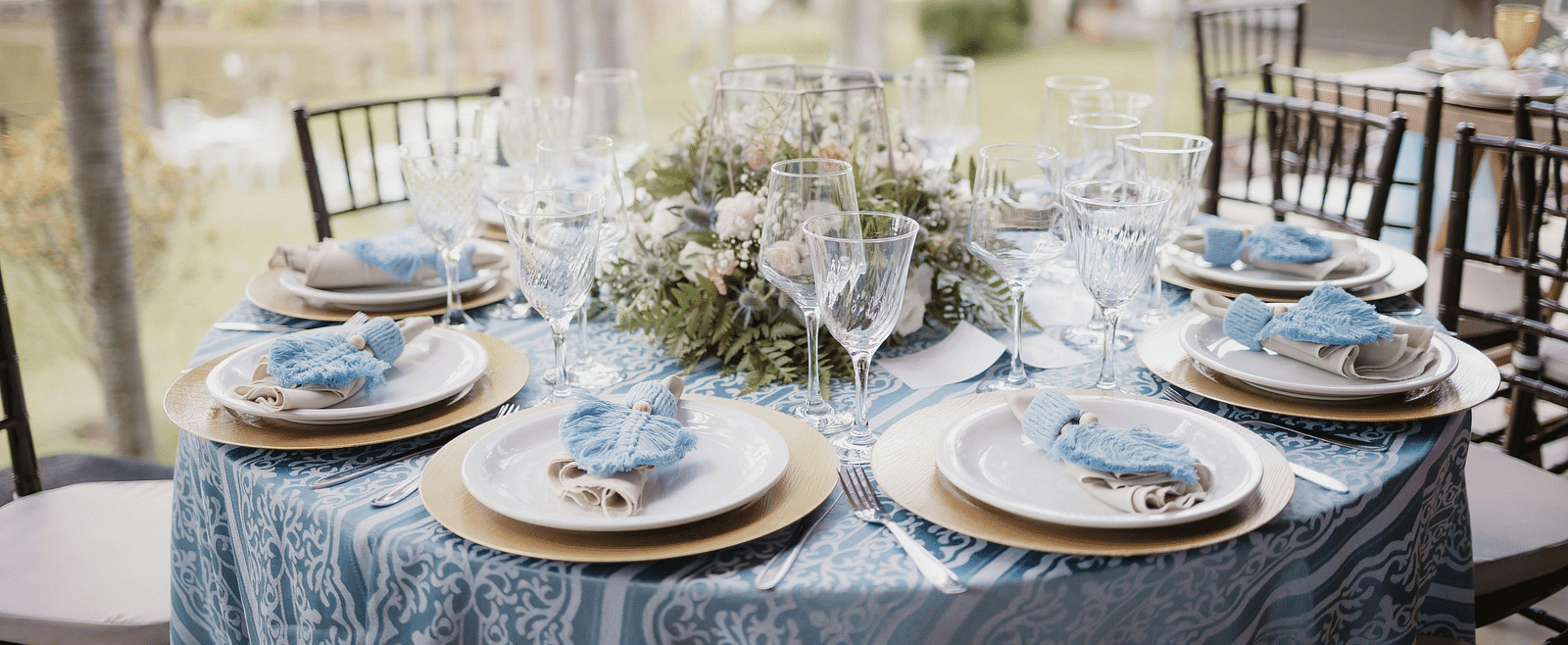 A beautifully arranged table and chairs, adorned for an event.