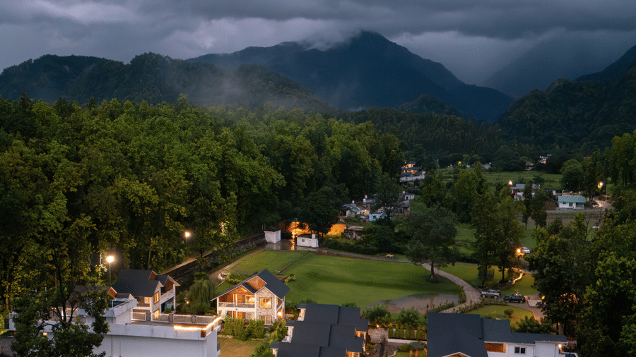 The view of Megha Resort & Villas, Dehradun featuring the hills & greenery under the clouded skt.