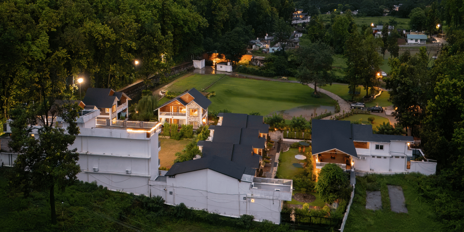 The view of Megha Resort & Villas, Dehradun featuring the hills & greenery under the clouded skt.