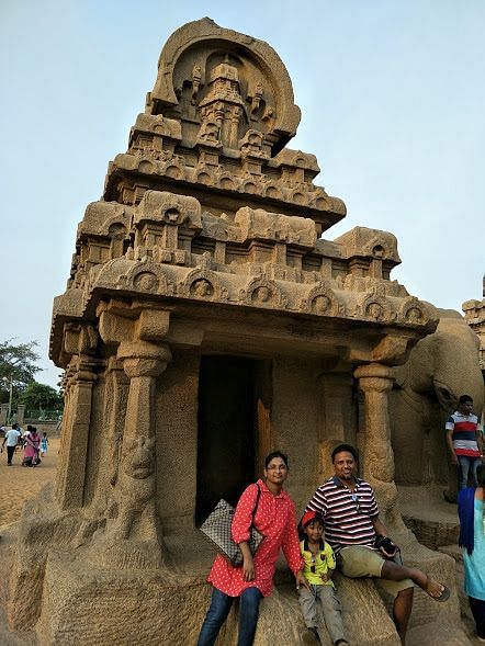 A family posing in front of the historical Mahabalipuram monument.