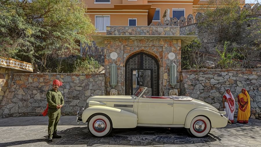 Facade of Khas Mahal by Fateh Collection, Udaipur featuring a vintage car parked in front of it.