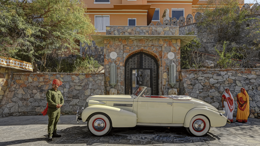 Khas Mahal Suites, Udaipur, featuring a vintage car parked in front of it.