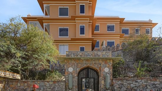Facade of Khas Mahal by Fateh Collection, Udaipur featuring a vintage car parked in front of it.
