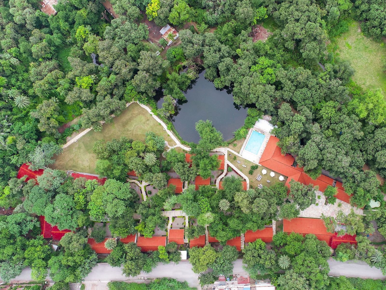 a drone shot of the luxury pond view villa nestled amidst serene greenery at our hotel in udaipur