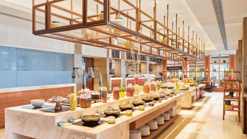 A buffet counter with multiple dishes, bowl, containers and plates | The Resort