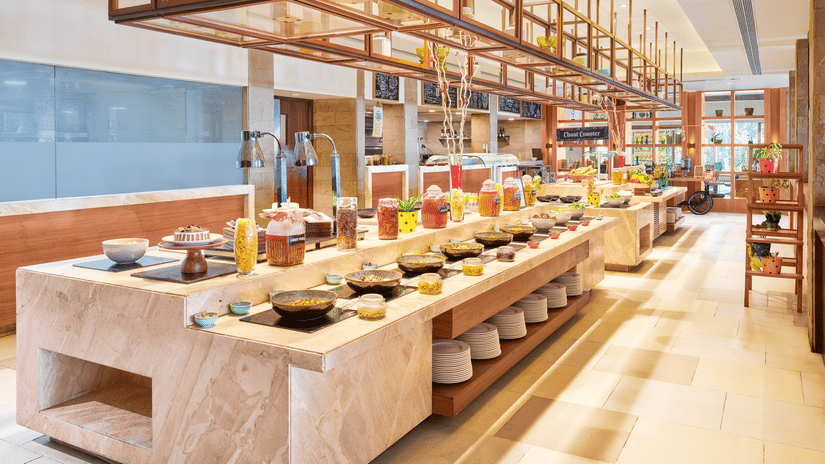 A buffet counter with multiple dishes, bowl, containers and plates | The Resort