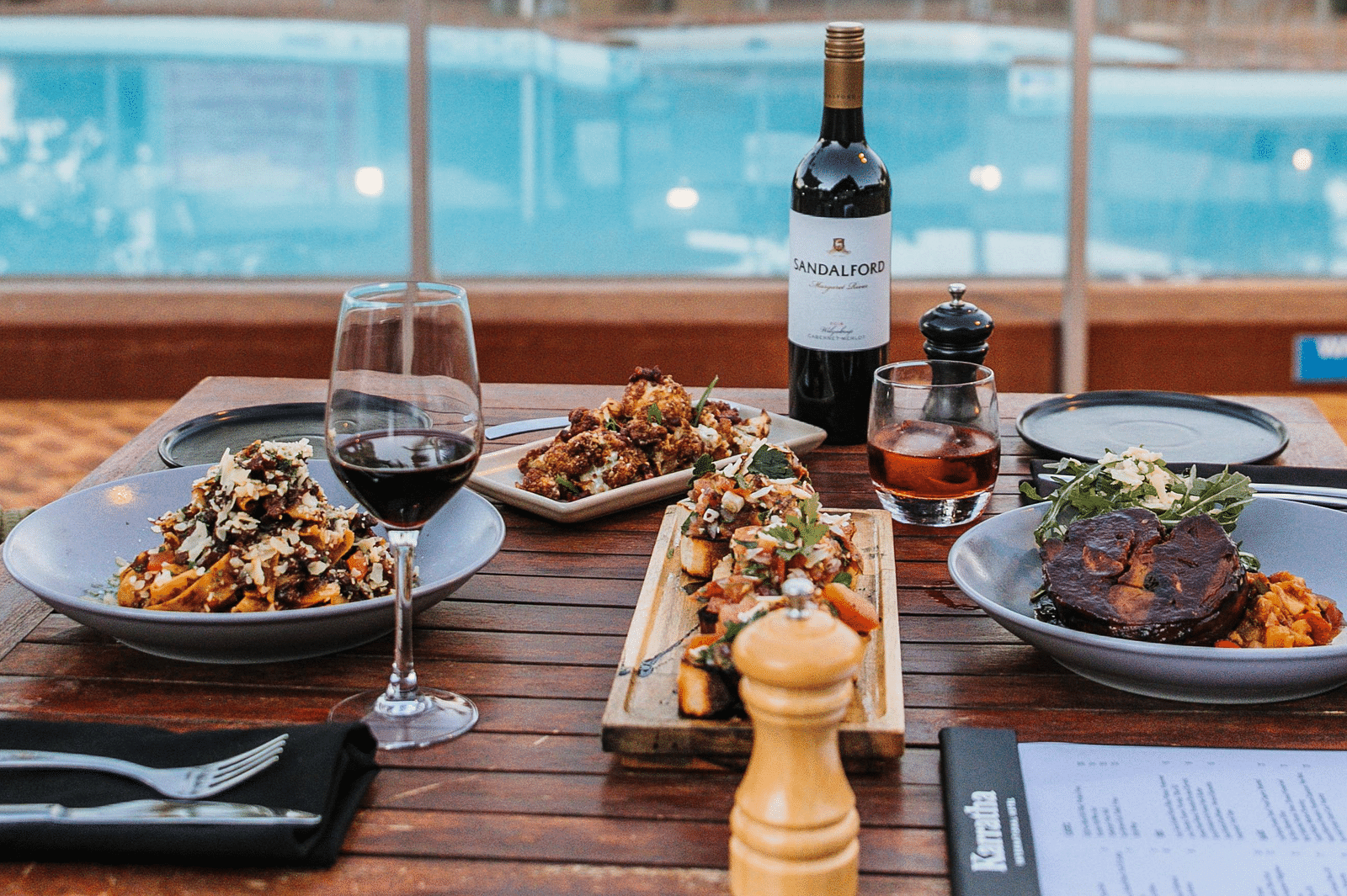 a table set beside a pool