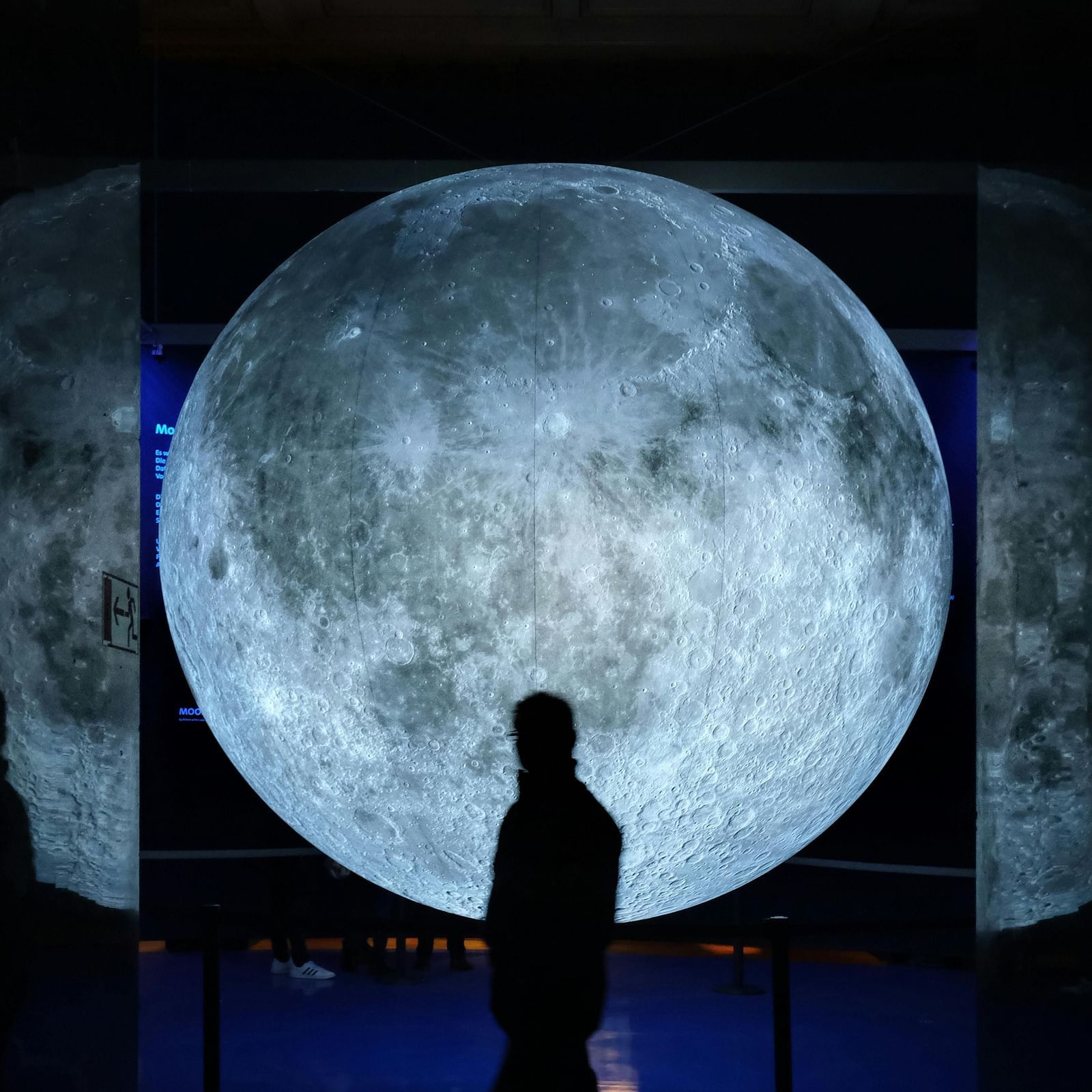an image of  a man looking at the illuminating moon 