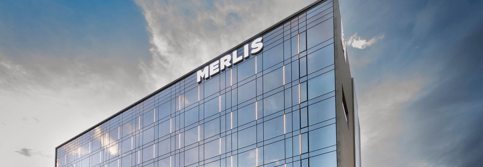 Angular architectural view of the hotel with a sleek glass exterior at Merlis Hotel, Coimbatore.