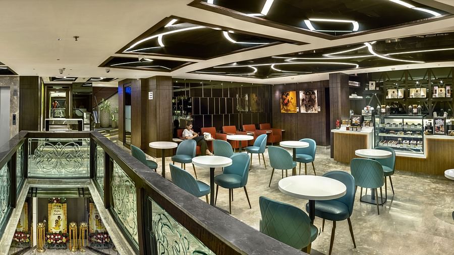 A modern office cafeteria with a variety of seating options, including tables and chairs, booths, and high-top counters- The Sonnet, Kolkata