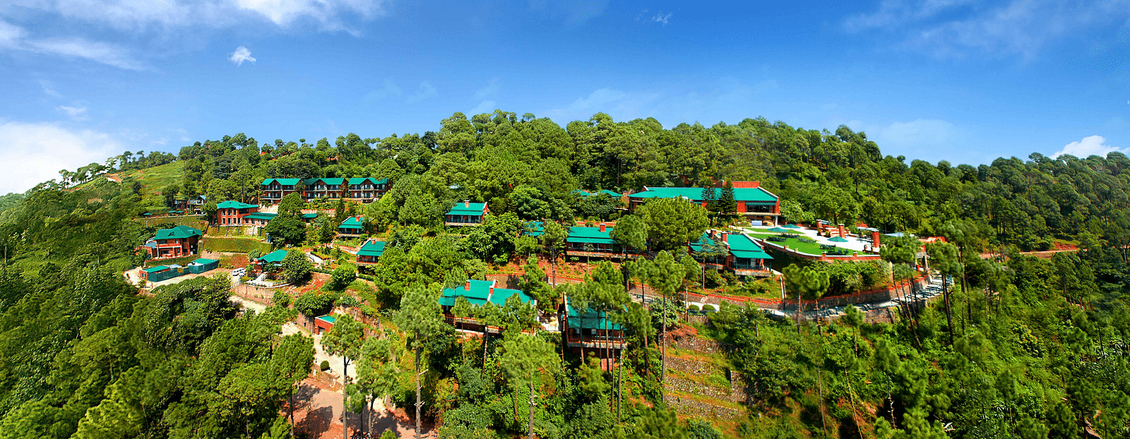 An aerial view of villas located on top of a mountain, bathed in daylight