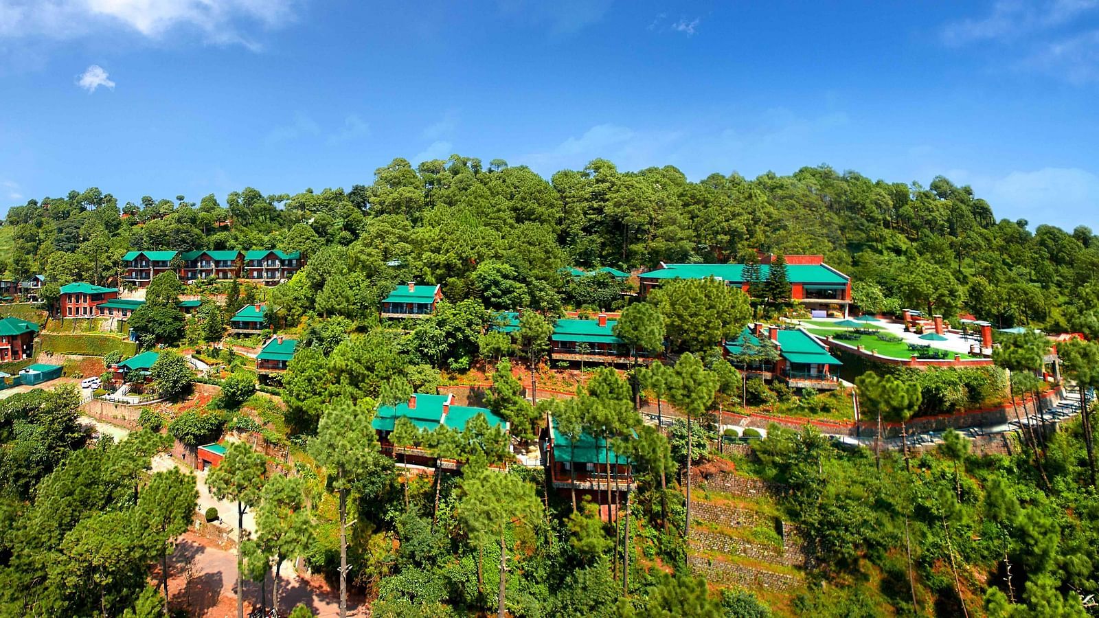 An aerial view of villas located on top of a mountain, bathed in daylight
