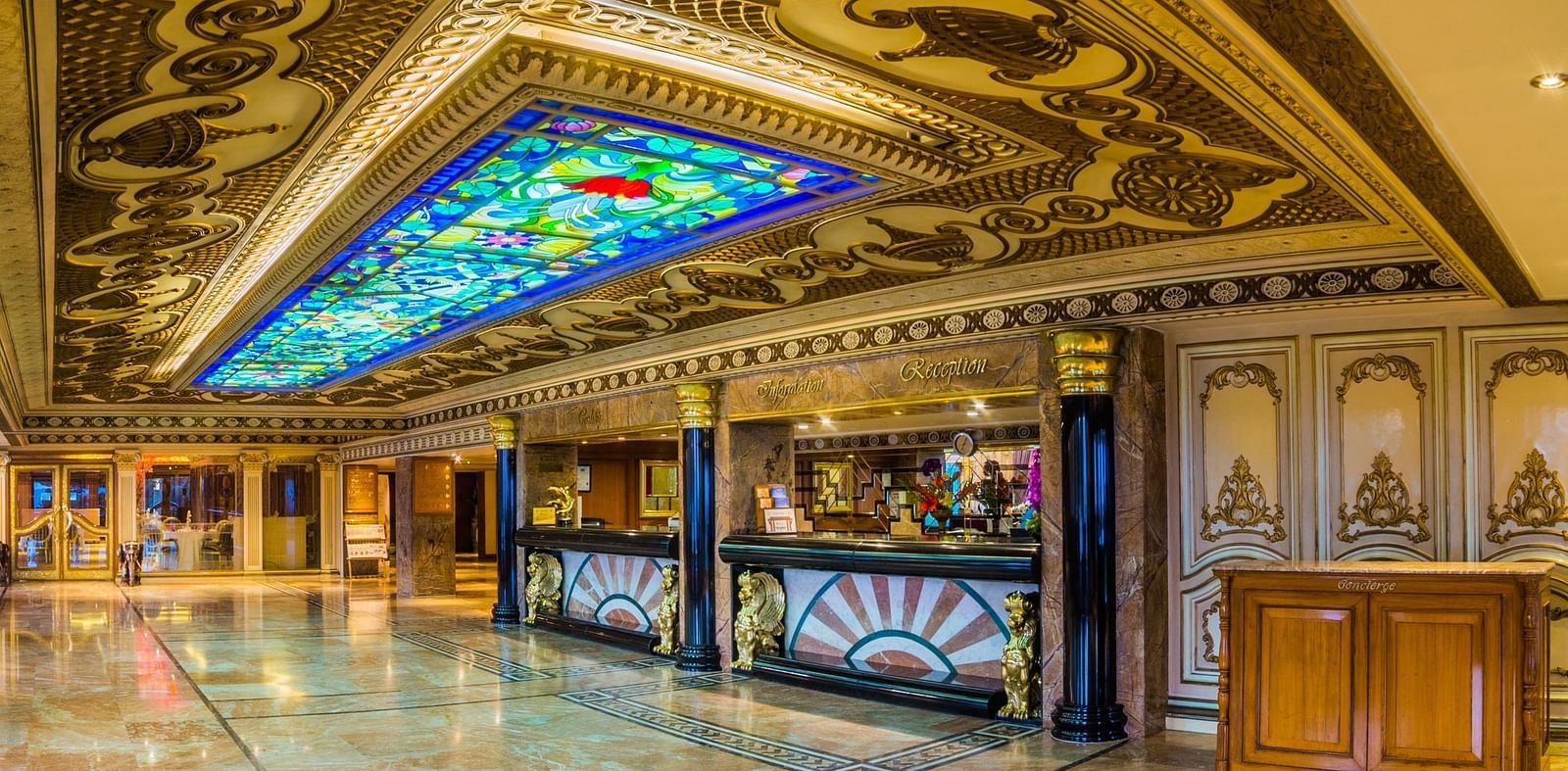 A grand and ornate hallway in a luxury hotel with elaborate arches and patterned carpets at  Sitara Luxury Hotel in Hyderabad near Ramoji Film City.