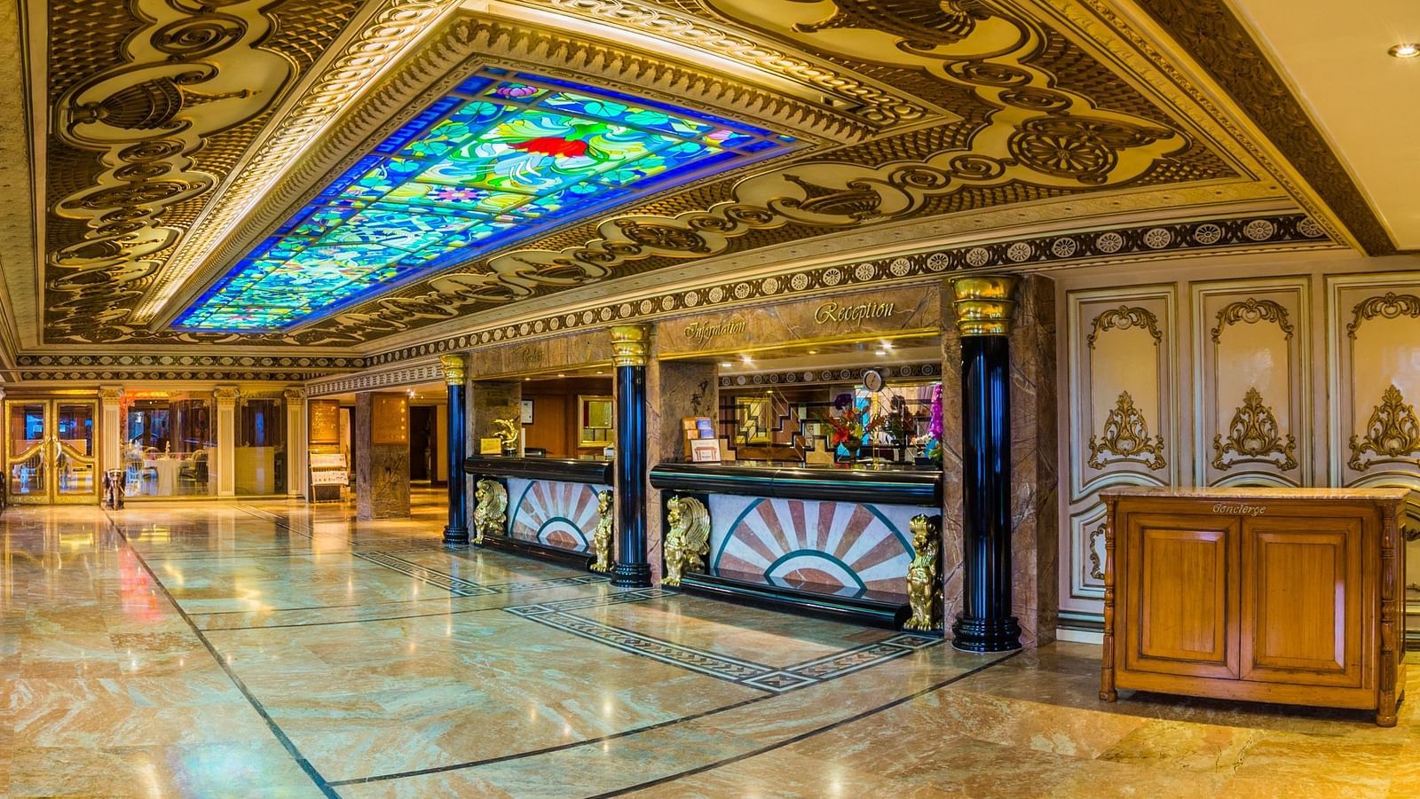 A grand and ornate hallway in a luxury hotel with elaborate arches and patterned carpets at  Sitara Luxury Hotel in Hyderabad near Ramoji Film City.