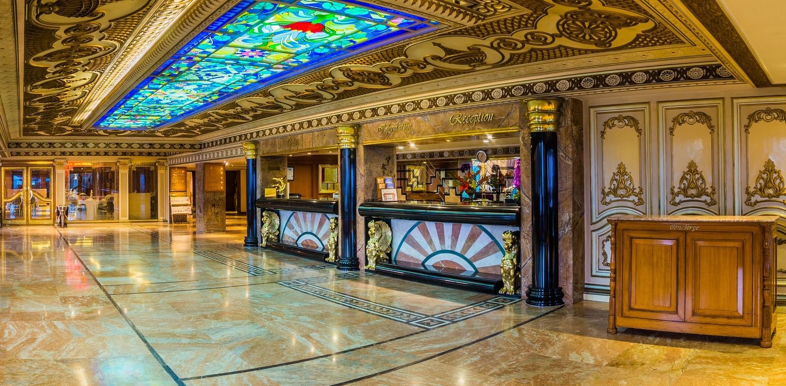 A grand and ornate hallway in a luxury hotel with elaborate arches and patterned carpets at  Sitara Luxury Hotel in Hyderabad near Ramoji Film City.