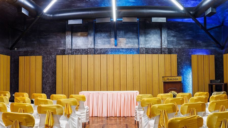Image featuring a well lit hall with high roof, Well arranged for an Event.
