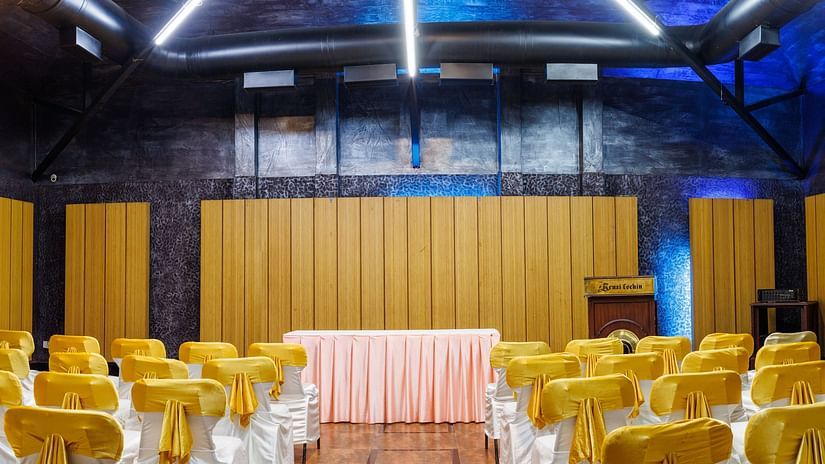Image featuring a well lit hall with high roof, Well arranged for an Event.