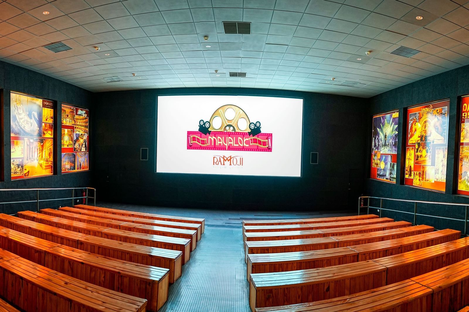 Interior view of Mayalok Theatre at Ramoji Film City, with large digital screens and illuminated wall panels.